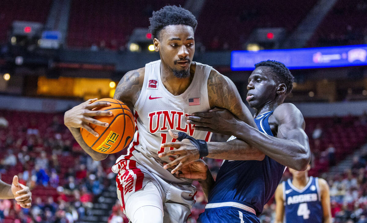 UNLV forward Kalib Boone (10) is held by Utah State Aggies forward Kalifa Sakho (34) during the ...