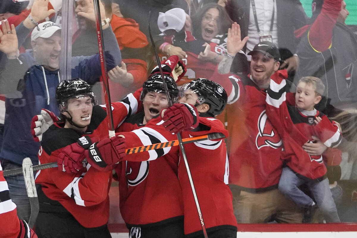 New Jersey Devils right wing Tyler Toffoli, center, celebrates scoring a hat trick and the winn ...