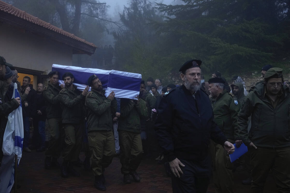 Israeli soldiers carry the flag-draped casket of reservist Ariel Mordechay Wollfstal during his ...