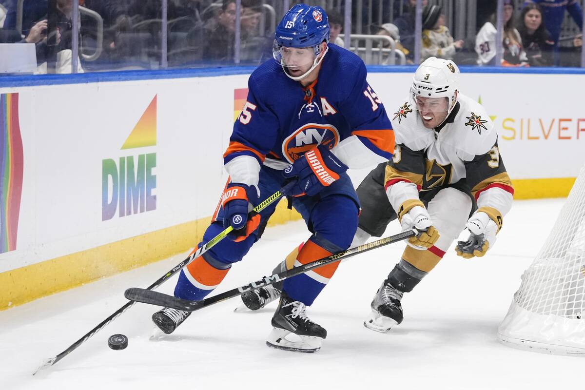 Vegas Golden Knights' Brayden McNabb (3) fights for control of the puck with New York Islanders ...