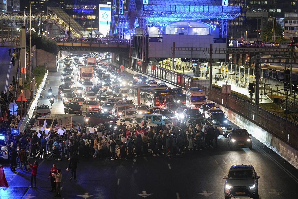 Israeli protesters block a highway during a protest demanding the immediate release of the Isra ...