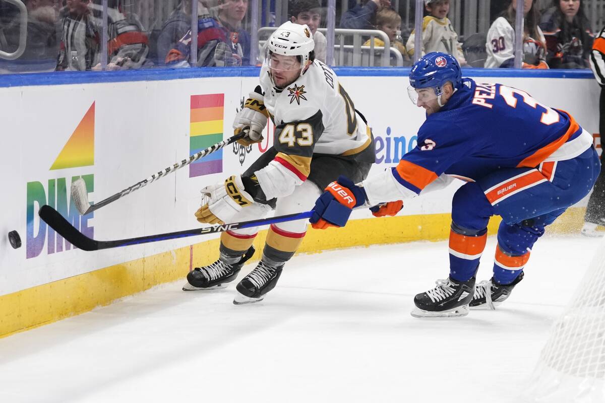 New York Islanders' Adam Pelech (3) and Vegas Golden Knights' Paul Cotter (43) reach for the pu ...