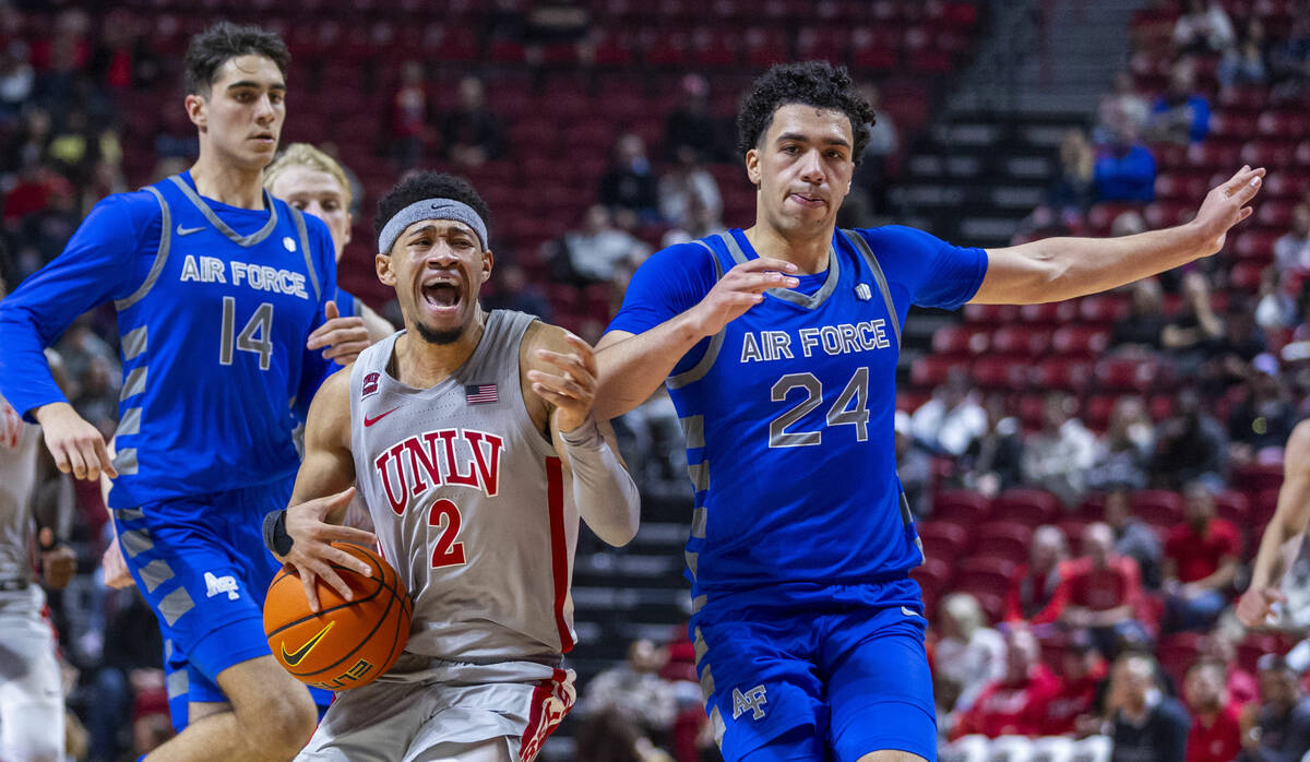 UNLV guard Justin Webster (2) is fouled hard on a drive by Air Force Falcons guard Jeffrey Mill ...