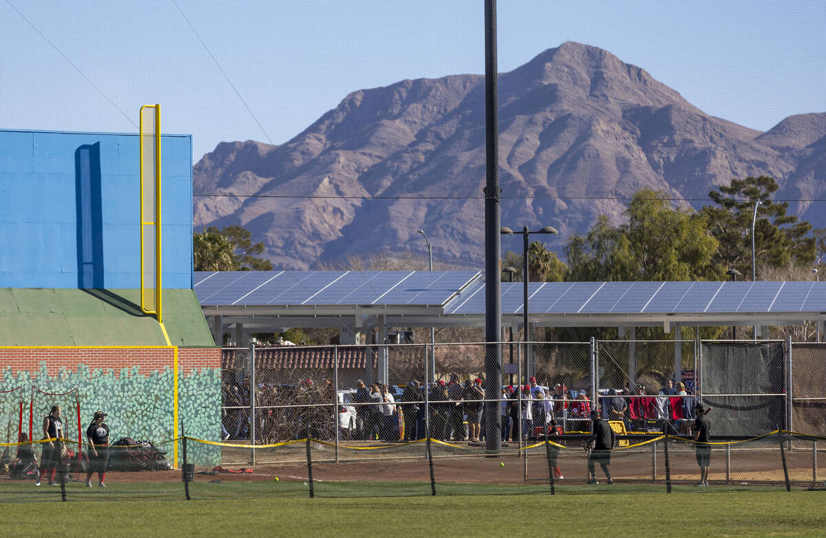Softball players warm up on a field as supporters line up outside to see Republican presidentia ...