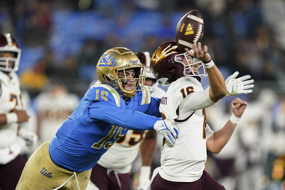 FILE - UCLA defensive lineman Laiatu Latu, left, pressures Arizona State quarterback Trenton Bo ...