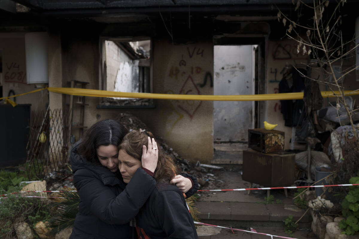 Amit Soussana, 40, right, is embraced by a friend after speaking to journalists in front of her ...