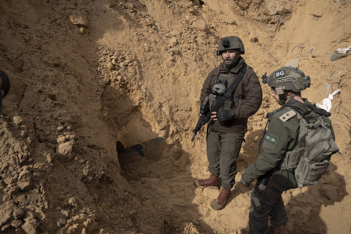 Israeli Brigadier General Dan Goldfus, left, stands by a Hamas tunnel underneath a cemetery dur ...