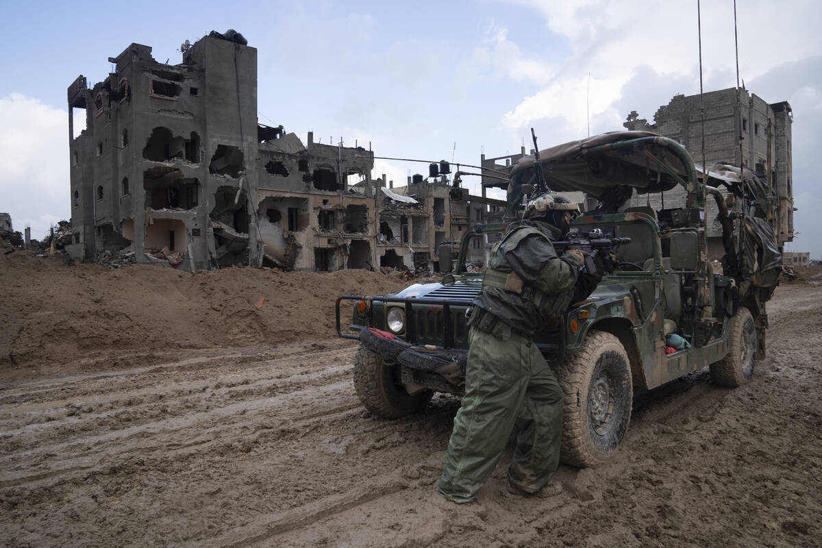 An Israeli soldier stands guard during the ground offensive on the Gaza Strip in Khan Younis, S ...