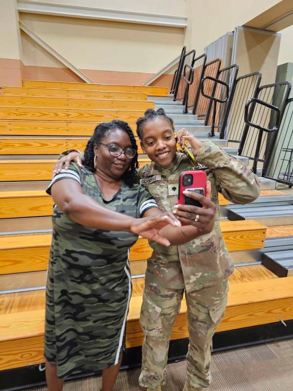 This undated image provided by Shawn Sanders shows Army Spc. Kennedy Sanders, right, posing for ...