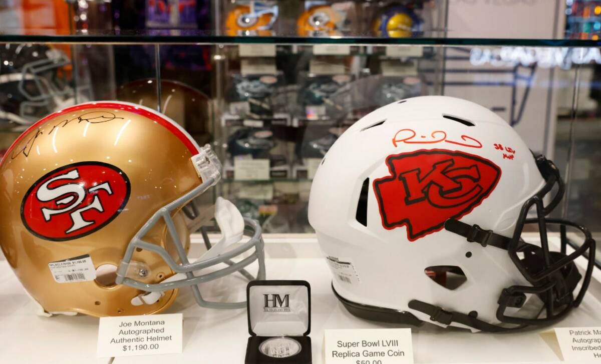 Authentic Helmets signed by Joe Montana, left, and Patrick Mahomes are displayed at the NFL Las ...