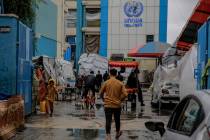 Palestinians walk at the entrance of a UNWRA school used as a shelter in Gaza City on Nov. 27, ...
