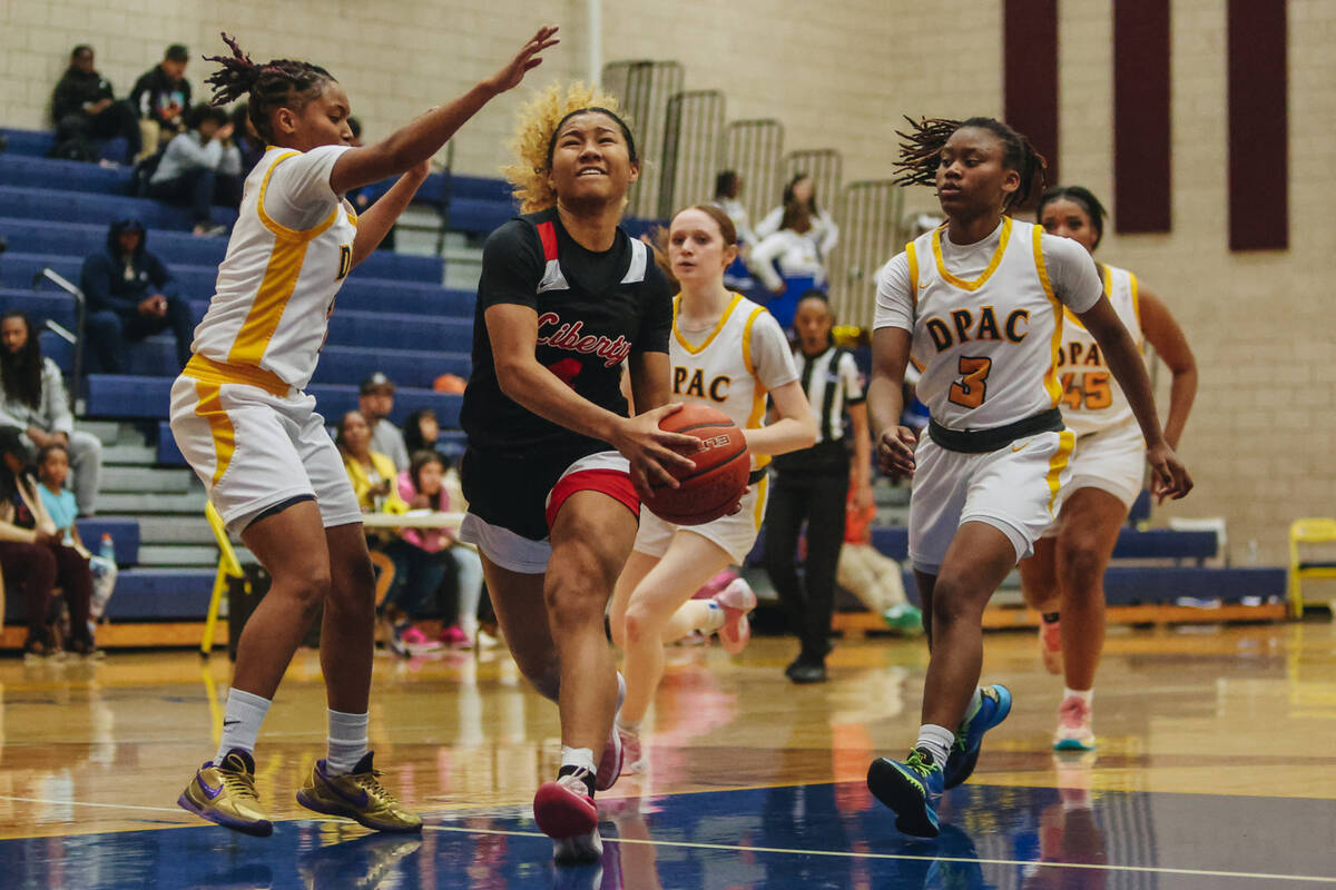 Liberty’s Satsuki Bradley (4) drives the ball to the basket during a basketball game between ...