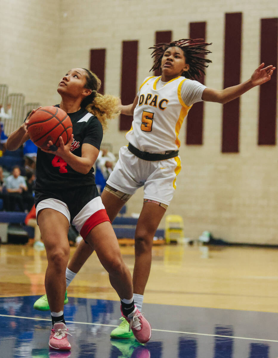 Liberty’s Satsuki Bradley (4) drives the ball to the hoop as Democracy Prep defender Kay ...