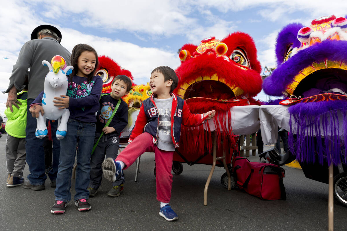 Jesse Jiang, 2, center, mimics the lion dance after the Lohan school of Shaolin performed durin ...