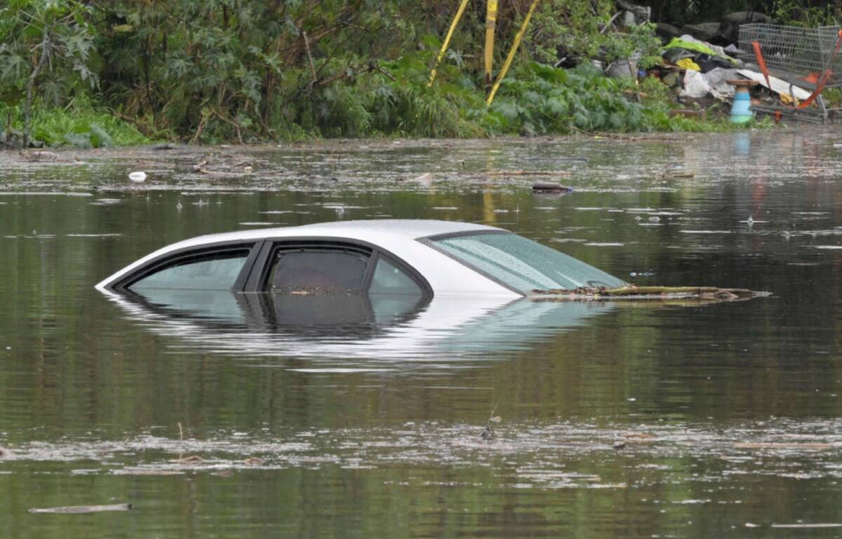 A car is nearly completely submerged under flood waters in Long Beach, Calif., Thursday, Feb. 1 ...