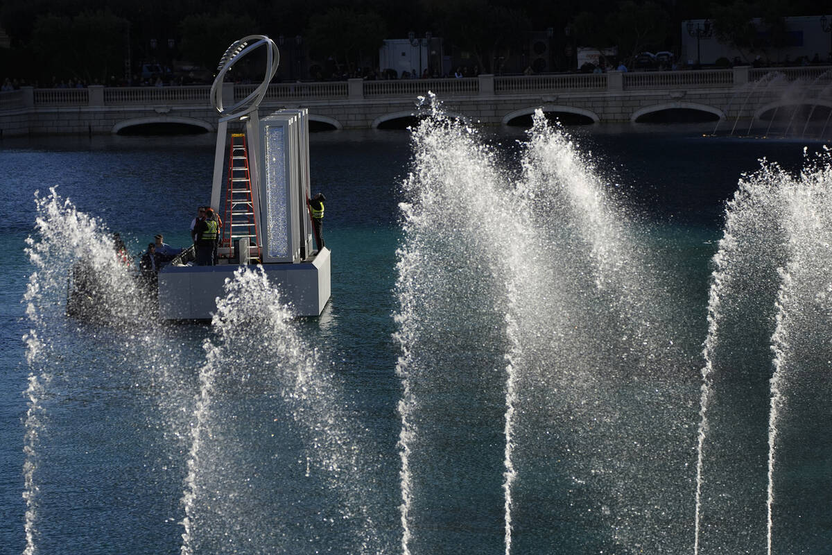 Workers erect a Lombardi Trophy statue at the Bellagio fountains ahead of the Super Bowl 58 foo ...