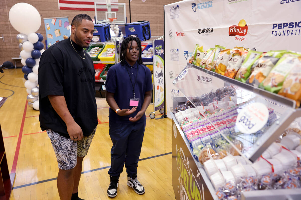NFL legend Rashad Jennings, left, checks out healthy grab and go food items with West Preparato ...