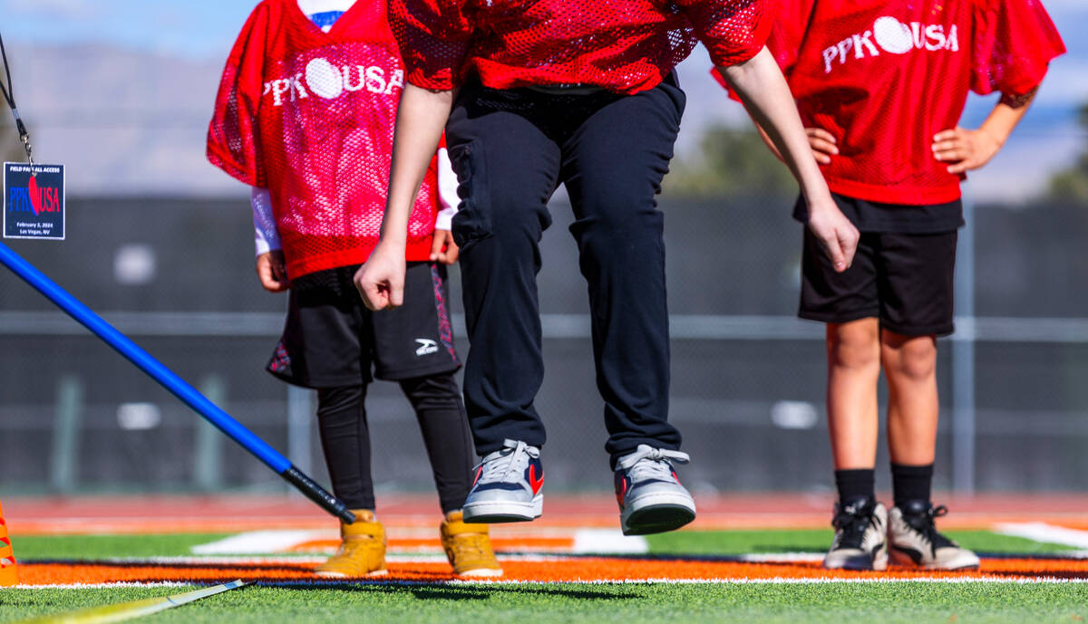 A 9/10-year-old boy's contestant leaps in a standing broad jump during the Punt, Pass and Kick ...