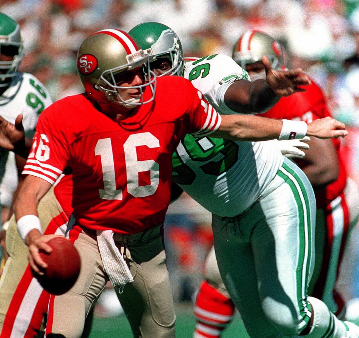 San Francisco 49ers quarterback Joe Montana is chased by Philadelphia Eagles Jerome Brown, righ ...