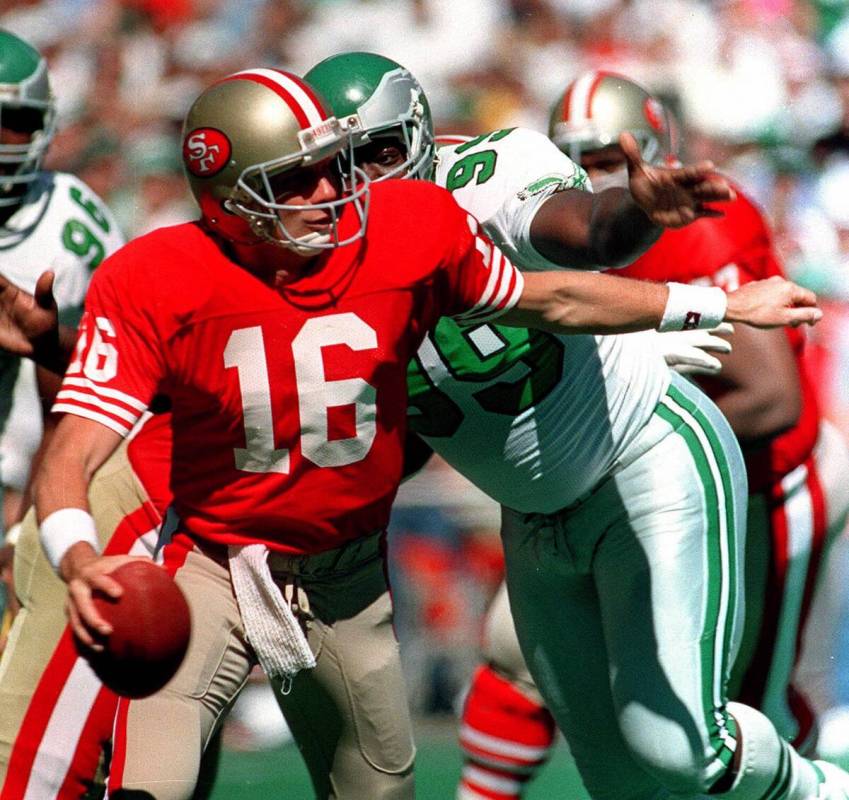 San Francisco 49ers quarterback Joe Montana is chased by Philadelphia Eagles Jerome Brown, righ ...