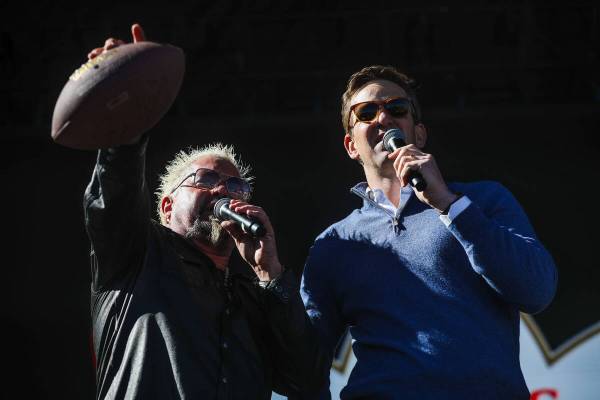 Guy Fieri, left, and Eli Manning, right, address the crowd before throwing signed footballs to ...