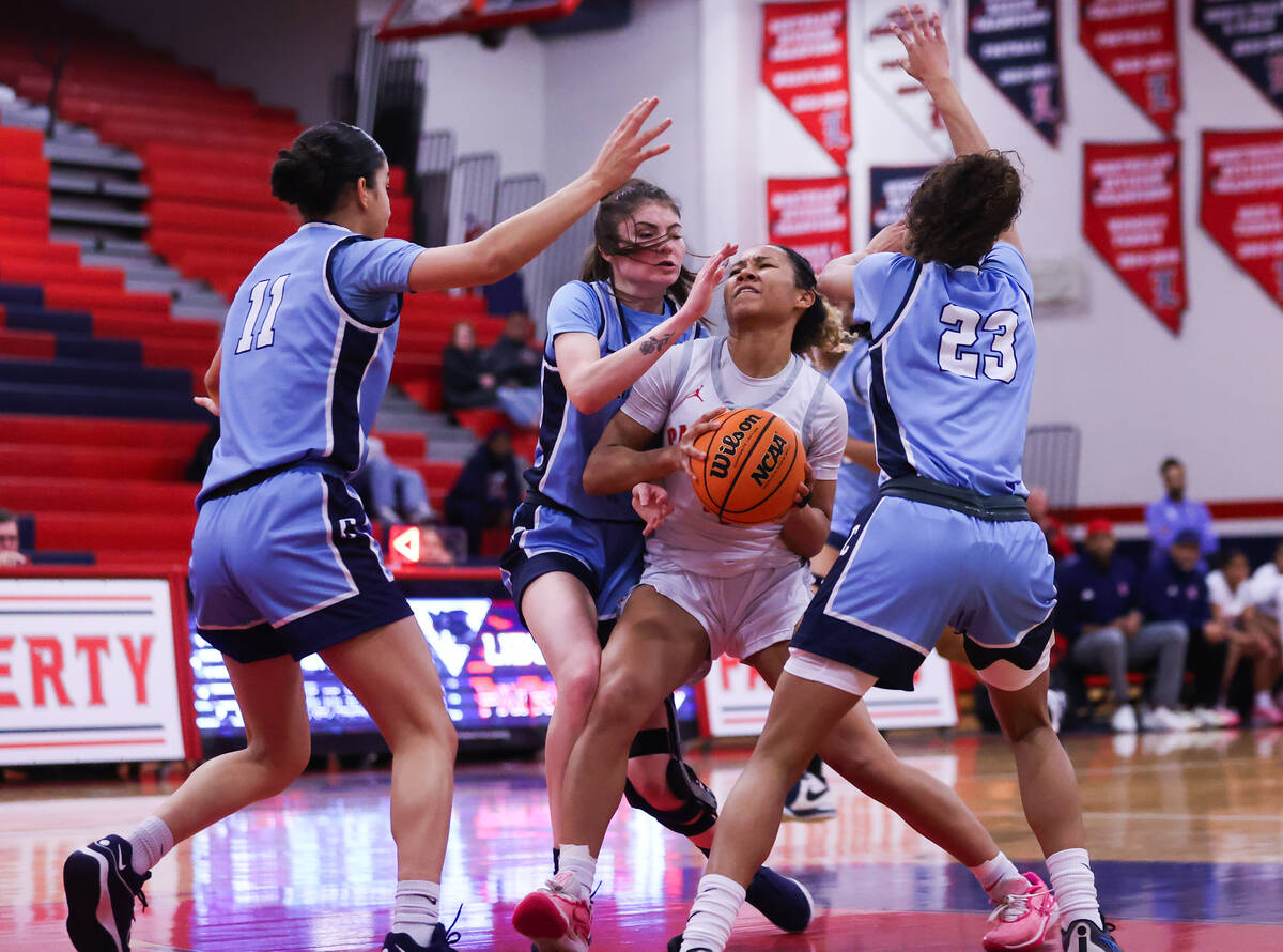 Liberty’s Satsuki Bradley (4) battles through Centennial players as she goes in for.a sh ...