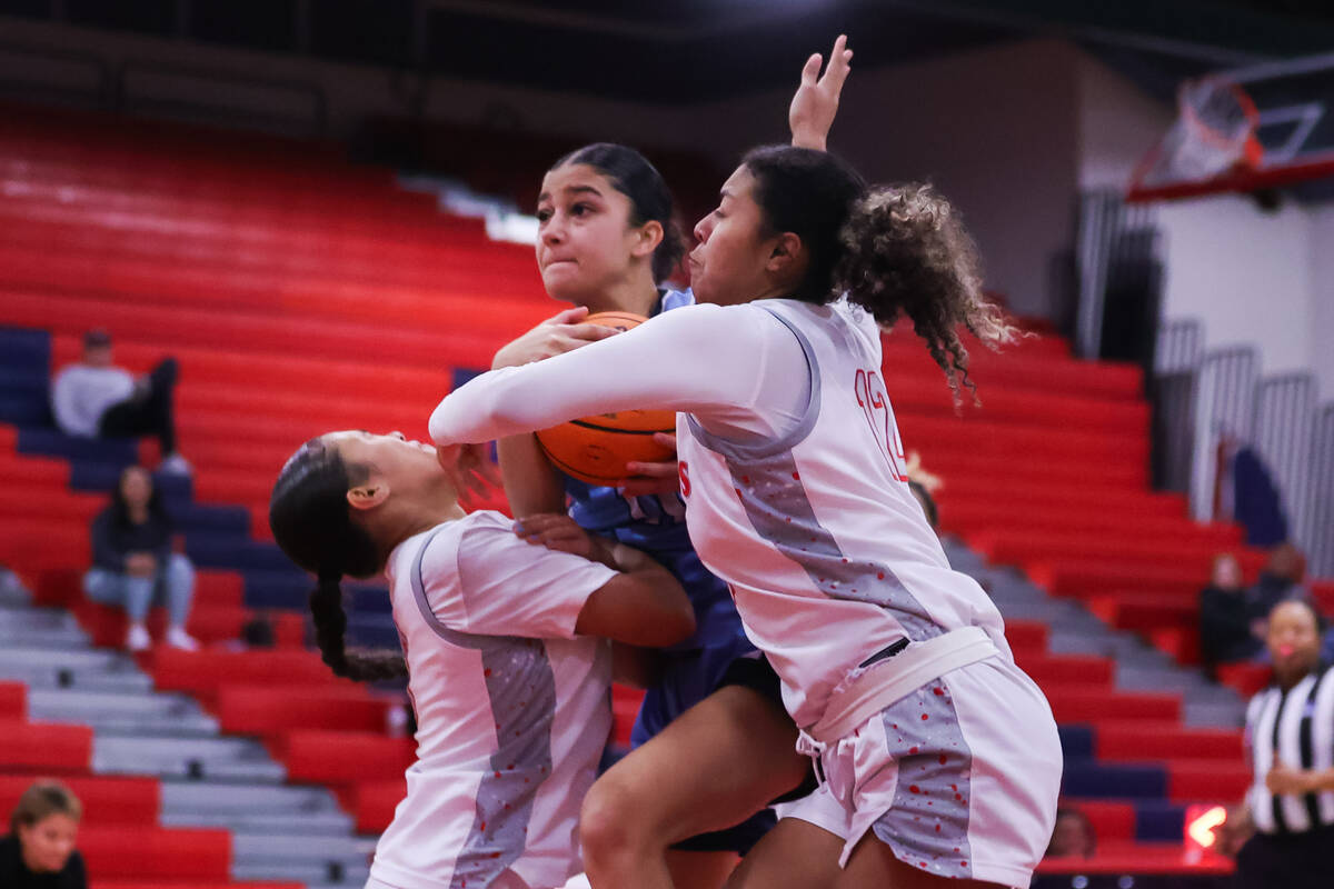 Centennial’s Danae Powell (11) pushes past Liberty’s Daisha Peavy (12) and anothe ...