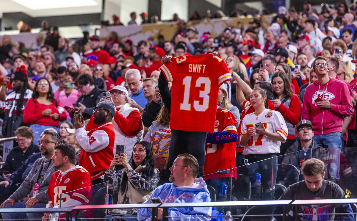 A fan holds up a Taylor Swift jersey in the stands during the Super Bowl Opening Night celebrat ...