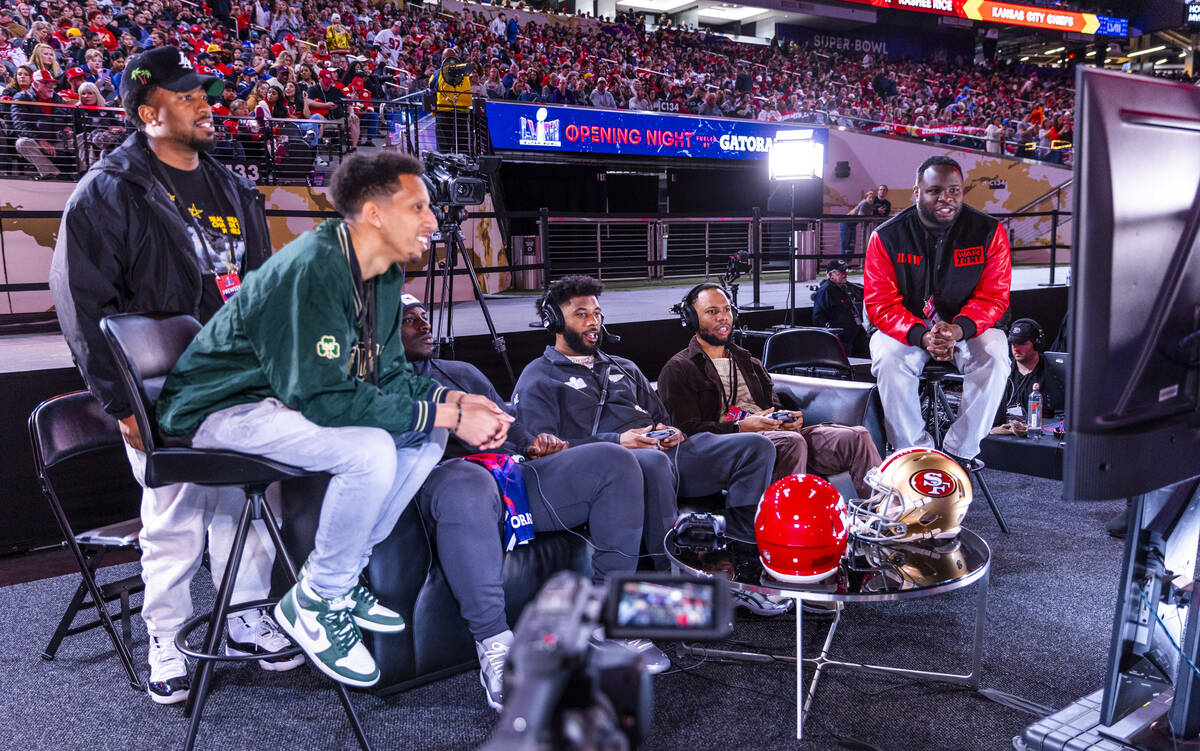 Kansas City Chiefs players and friends play a video game on the field during the Super Bowl Ope ...