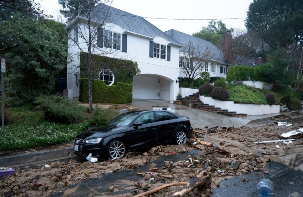 A car damages from mud, rock and debris flows along Fryman Road in Studio City, Calif., has cau ...