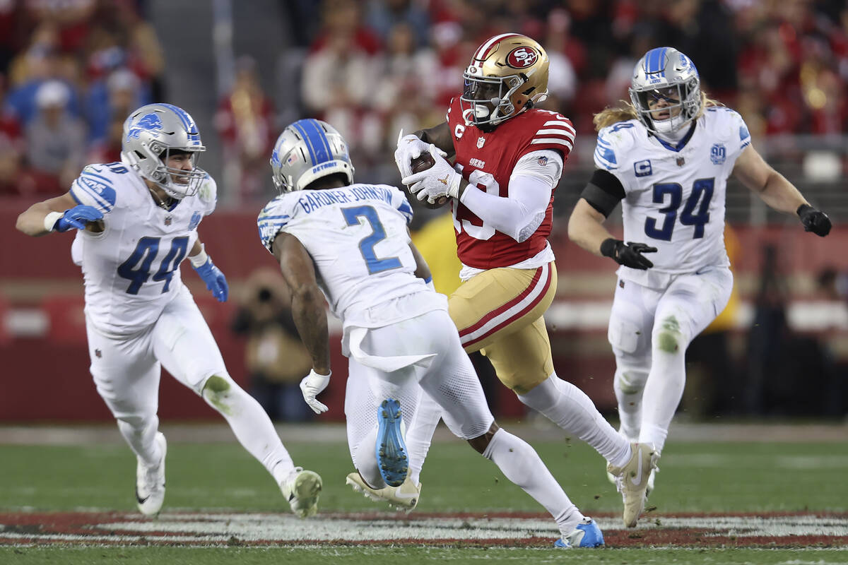 San Francisco 49ers wide receiver Deebo Samuel, middle right, runs against Detroit Lions lineba ...