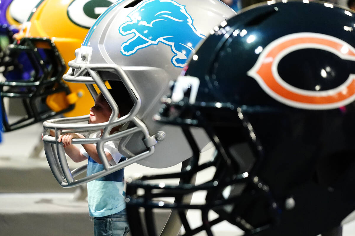 A young fan tries on an oversized football helmet at the Super Bowl Experience, on opening day ...