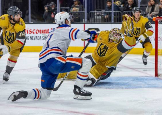 Golden Knights goaltender Adin Hill (33) deflects a shot on goal by Edmonton Oilers center Ryan ...