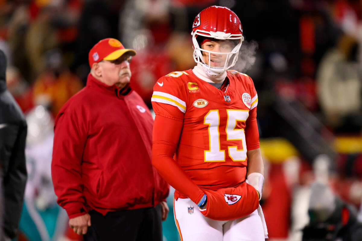 Kansas City Chiefs head coach Andy Reid, in back, watches his team during warmups in below-zero ...