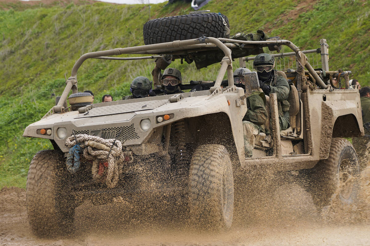 Israeli soldiers drive near the border with the Gaza Strip, as seen in southern Israel, Tuesday ...