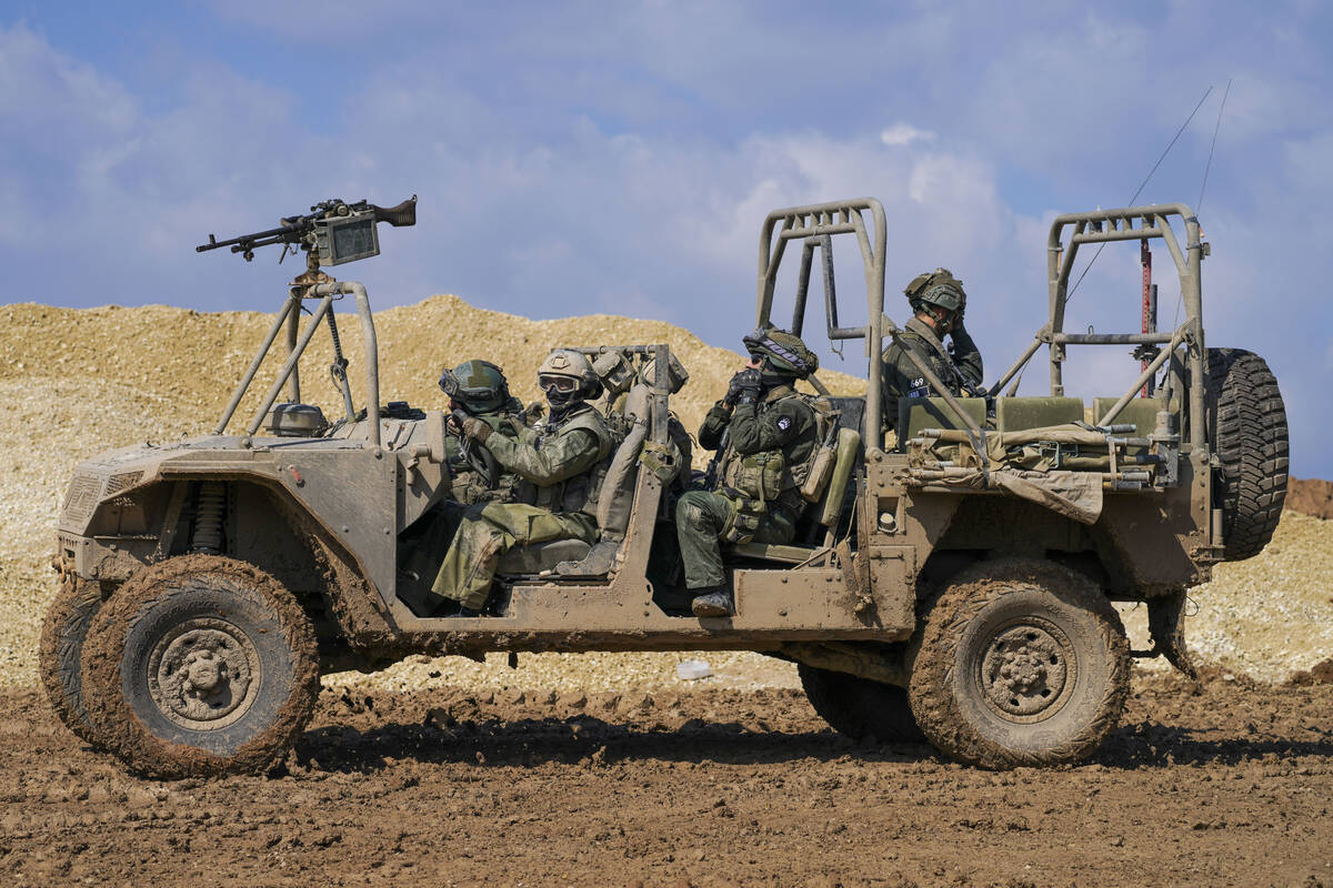 Israeli soldiers drive near the border with the Gaza Strip, as seen in southern Israel, Tuesday ...