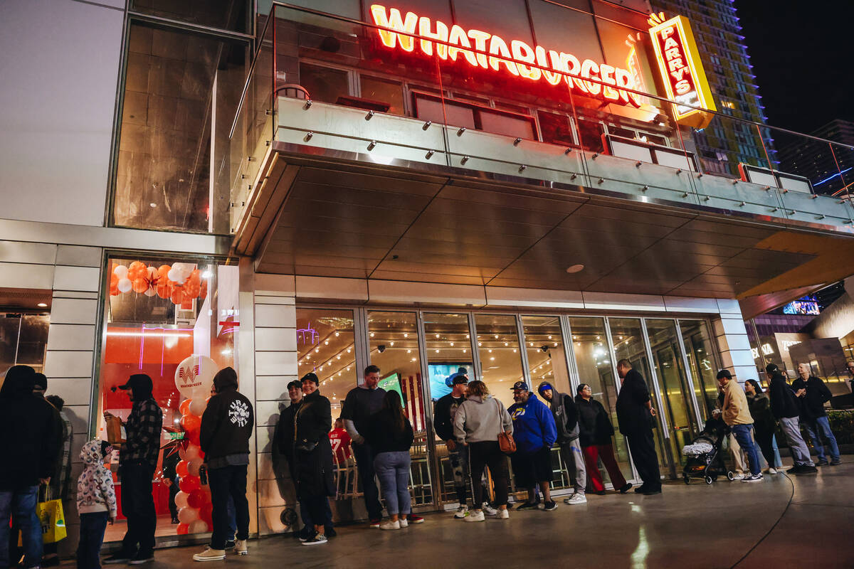 Customers wait in a long line to experience Whataburger on opening day Wednesday, Feb. 7, 2024, ...