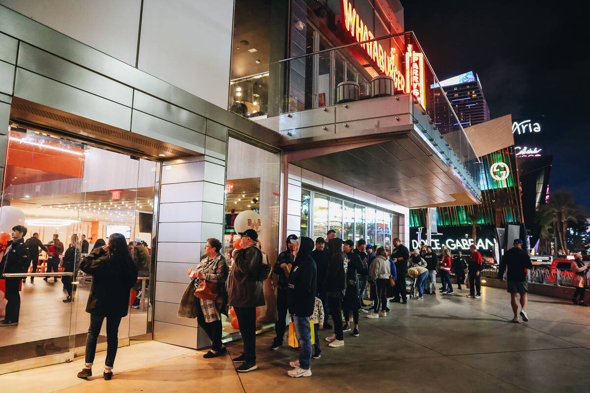 Customers wait in a long line to experience Whataburger on opening day Wednesday, Feb. 7, 2024, ...