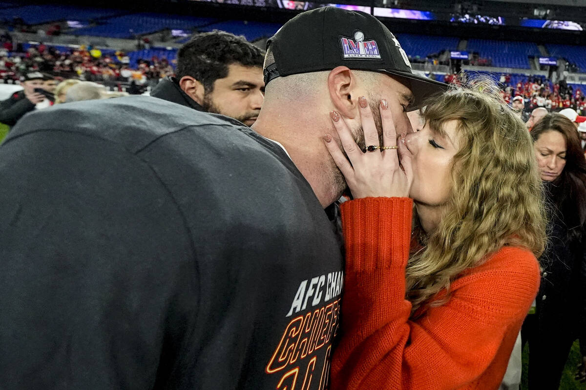 Taylor Swift kisses Kansas City Chiefs tight end Travis Kelce after an AFC Championship NFL foo ...