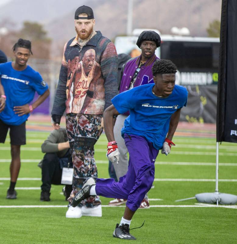 Raiders defensive end Maxx Crosby, left, looks on as a participant of the Field the Future Madd ...