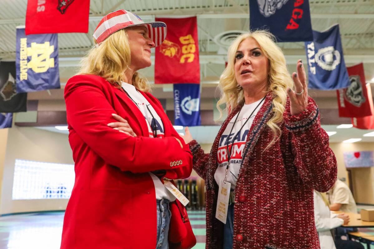 Trump Caucus Captains Shannon Fore, left, and Kris Madsen, speak with eachother at a caucus cen ...