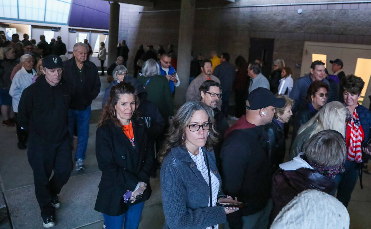 Voters wait in line to vote at a caucus center located at Sig Rogich Middle School in Summerlin ...