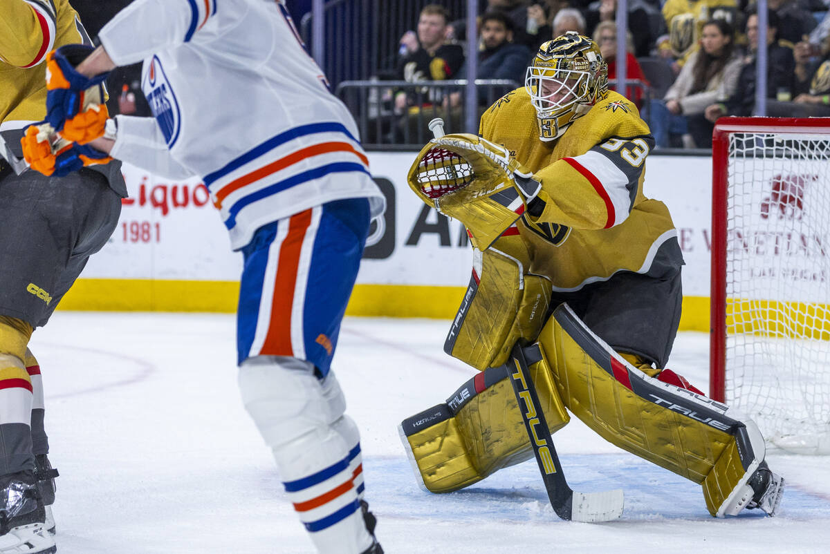 Golden Knights goaltender Adin Hill (33) takes a puck to the chest for another great save again ...