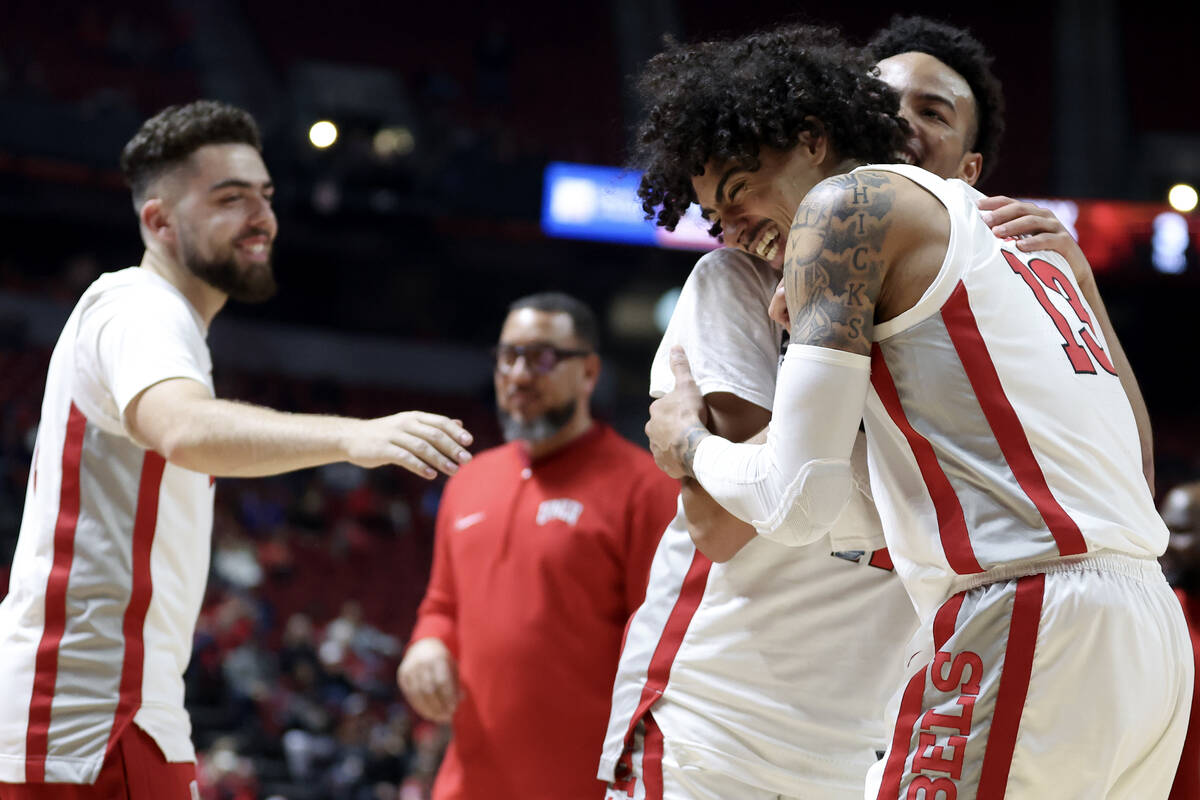 UNLV Rebels guard Brooklyn Hicks (13) hugs guard Dedan Thomas Jr. (11) as they head into a time ...