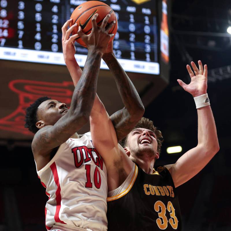 UNLV Rebels forward Kalib Boone (10) and Wyoming Cowboys forward Mason Walters (33) jump for a ...