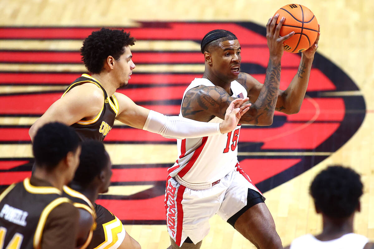 UNLV Rebels guard Luis Rodriguez (15) passes against Wyoming Cowboys guard Brendan Wenzel (1) d ...