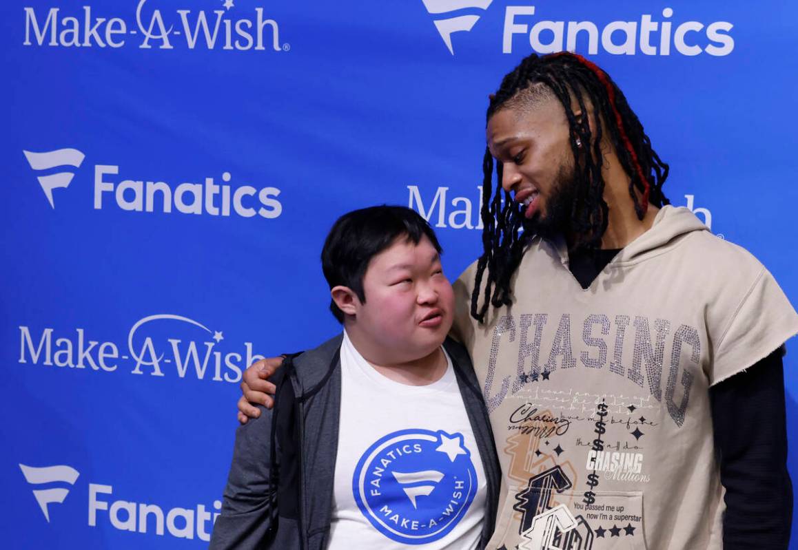 Bills' Damar Hamlin chats with Samuel Long as they pose for a photo at the Lids Flagship Store, ...