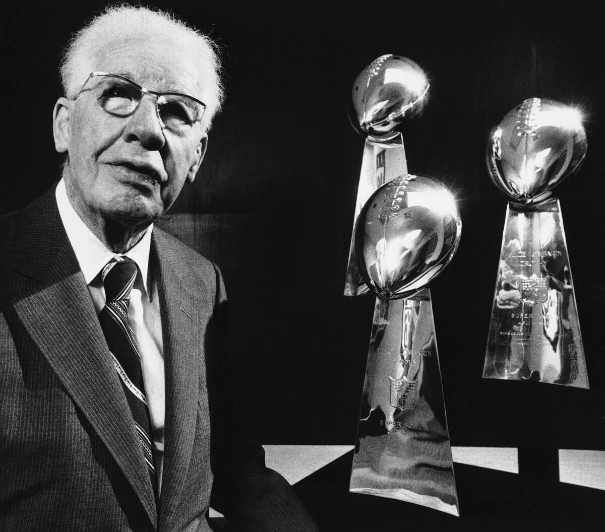 Art Rooney, Sr., owner of the Pittsburgh Steelers poses with his team's three Super Bowl Trophi ...