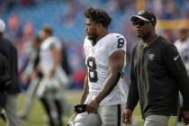 Raiders running back Josh Jacobs (8) walks off the field with wide receiver coach Edgar Bennett ...