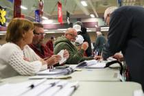 Voters sign in to vote at a caucus center located at Sig Rogich Middle School in Summerlin duri ...